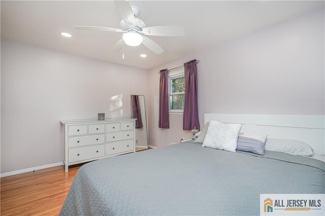 bedroom with light hardwood / wood-style floors and ceiling fan