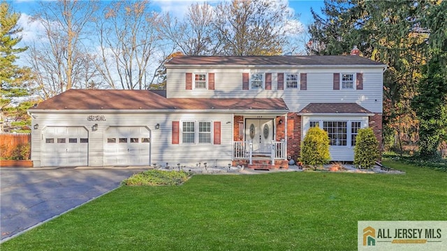 view of front of property with driveway, an attached garage, and a front yard