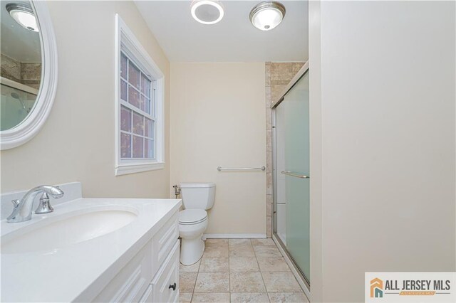 bathroom with toilet, vanity, and walk in shower