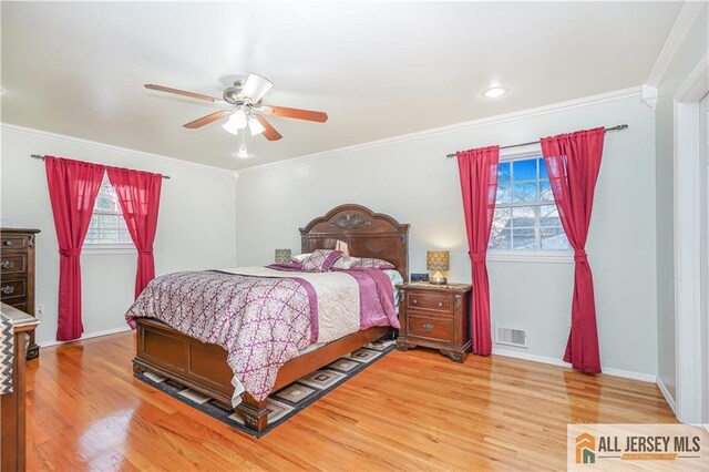 bedroom with hardwood / wood-style floors, crown molding, and ceiling fan