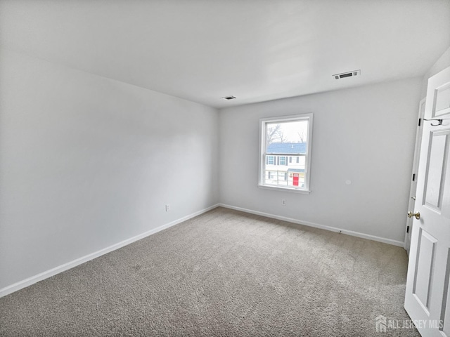 carpeted spare room featuring baseboards