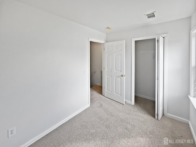 unfurnished bedroom featuring carpet flooring, baseboards, and a closet
