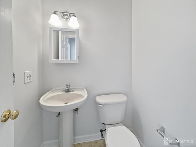 half bath with toilet and baseboards