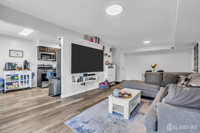 living area featuring light wood-style flooring and baseboards