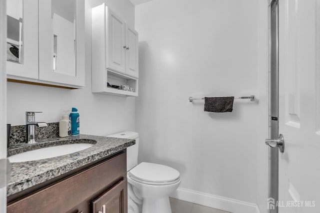 bathroom featuring tile patterned floors, toilet, vanity, and baseboards