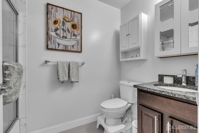 full bathroom featuring vanity, toilet, baseboards, and a shower with door