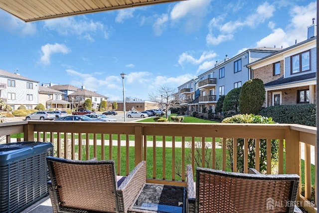 wooden terrace featuring a yard, a residential view, and central AC