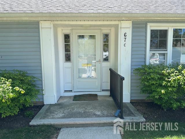 entrance to property with roof with shingles