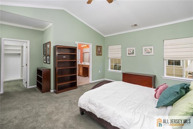 bedroom featuring a walk in closet, carpet, visible vents, ornamental molding, and vaulted ceiling