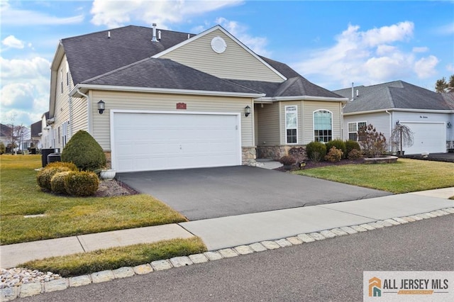 view of front of property with an attached garage, stone siding, aphalt driveway, and a front lawn