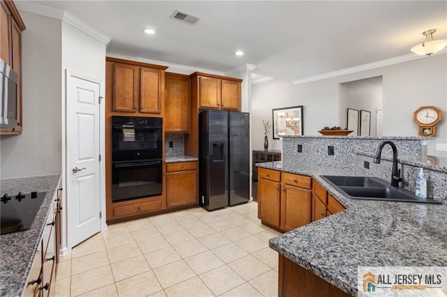 kitchen featuring a sink, visible vents, black appliances, brown cabinetry, and crown molding