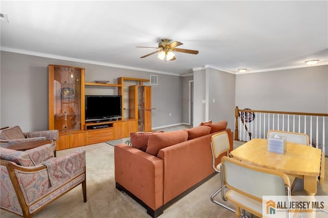 living area with a ceiling fan, light colored carpet, crown molding, and visible vents