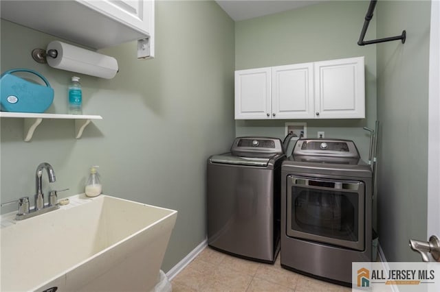 laundry room featuring cabinet space, baseboards, independent washer and dryer, a sink, and light tile patterned flooring