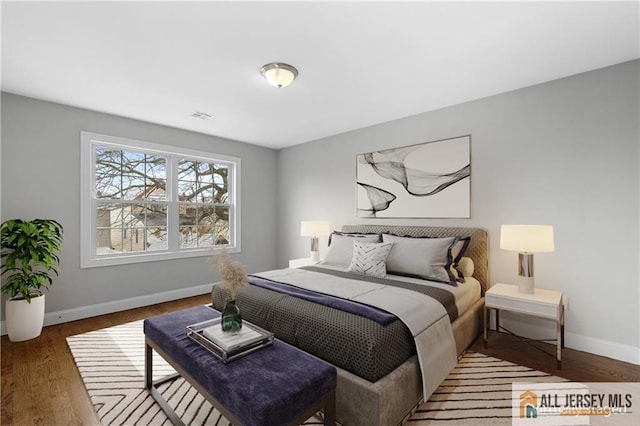 bedroom featuring visible vents, baseboards, and wood finished floors