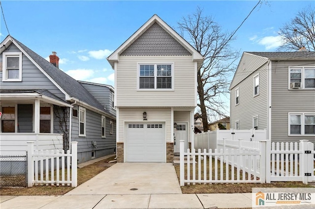 view of front facade with concrete driveway, a garage, and fence