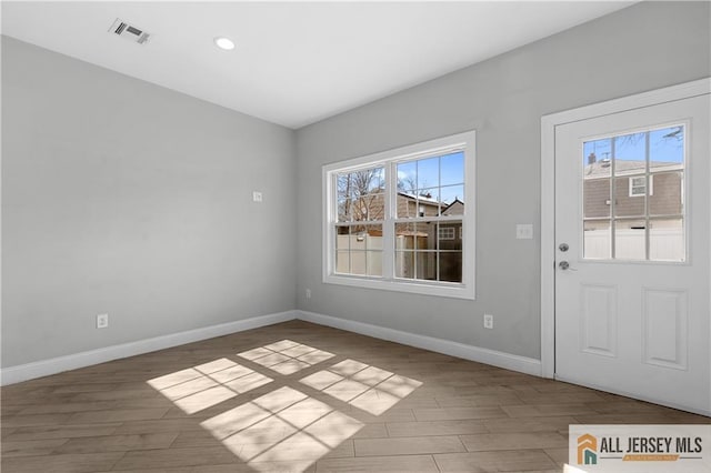 interior space with visible vents, baseboards, and wood finished floors