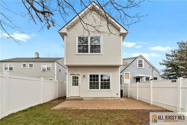 back of property with a patio area, a lawn, and a fenced backyard