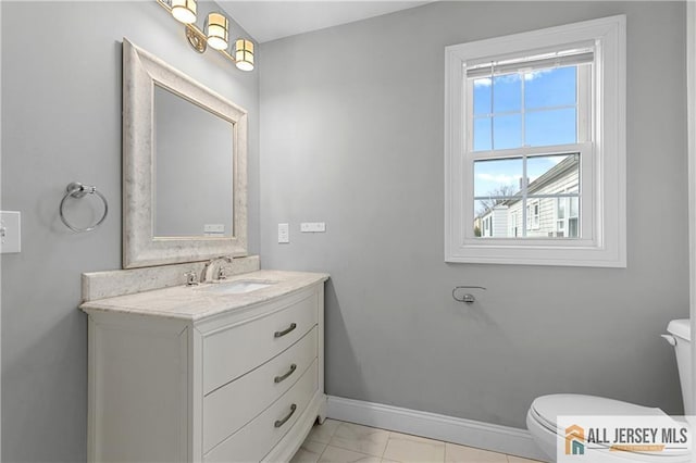 half bathroom featuring baseboards, toilet, and vanity