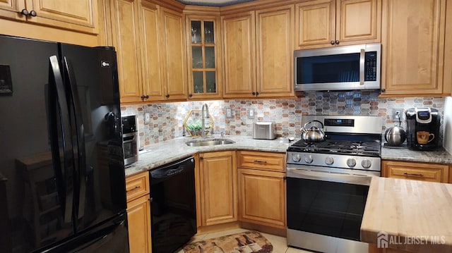 90 Clay St, North Brunswick, NJ 08902 - kitchen featuring black appliances, a sink, decorative backsplash, and light stone countertops