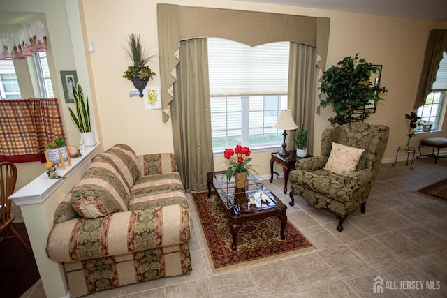 living area with baseboards, plenty of natural light, and tile patterned flooring