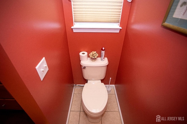 bathroom featuring tile patterned flooring, baseboards, and toilet