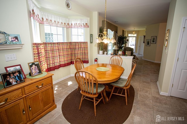 dining area with tile patterned floors, an inviting chandelier, and baseboards