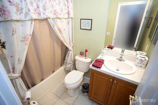 full bath featuring vanity, toilet, tile patterned floors, shower / bath combo with shower curtain, and baseboards