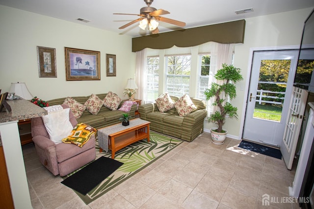living area with light tile patterned floors, ceiling fan, and visible vents