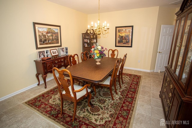 dining room featuring baseboards, light tile patterned flooring, and a notable chandelier