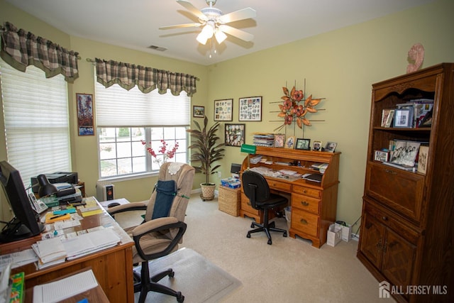 carpeted home office featuring baseboards, a ceiling fan, and visible vents