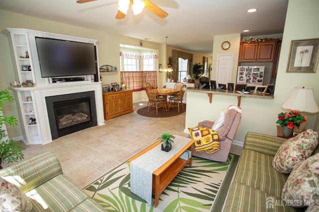 living room with a ceiling fan, recessed lighting, a glass covered fireplace, and light tile patterned floors