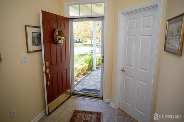 entrance foyer with baseboards and light tile patterned floors
