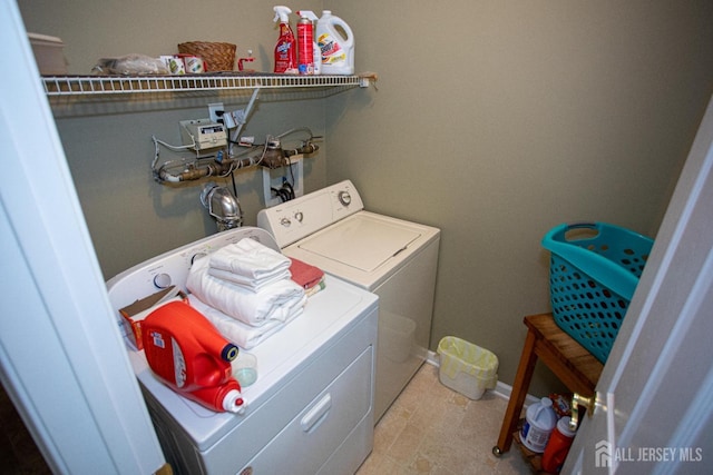 laundry room with separate washer and dryer, laundry area, and baseboards