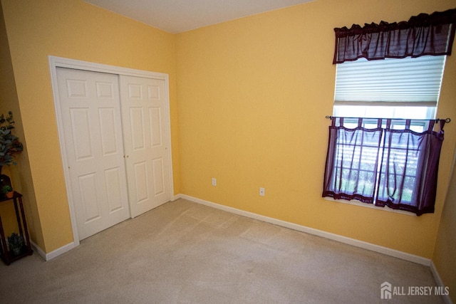 unfurnished bedroom featuring a closet, carpet flooring, and baseboards
