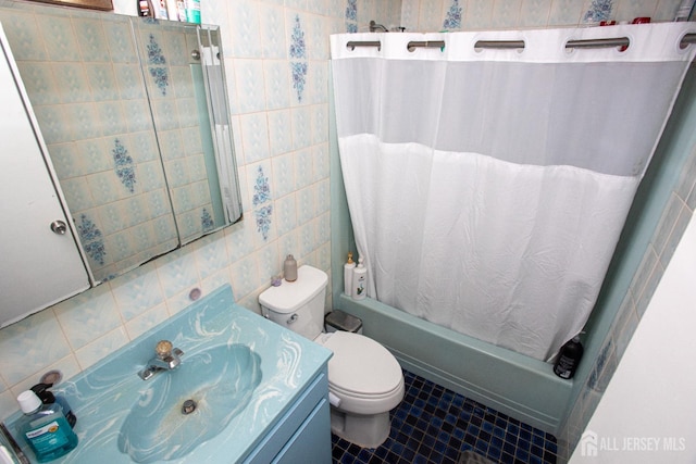 full bath with tile walls, toilet, shower / bath combo, vanity, and tile patterned floors