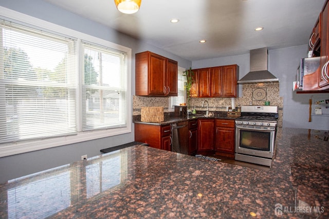 kitchen with recessed lighting, a sink, appliances with stainless steel finishes, decorative backsplash, and wall chimney exhaust hood