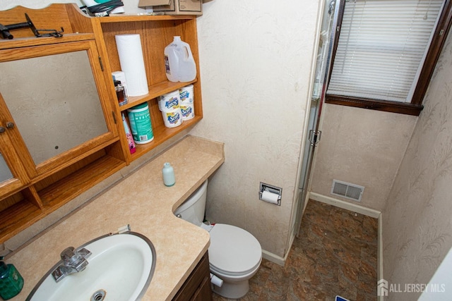 full bathroom with baseboards, visible vents, vanity, and toilet