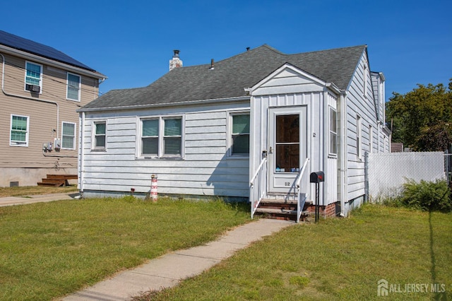 view of front of property featuring entry steps, a chimney, board and batten siding, and a front yard