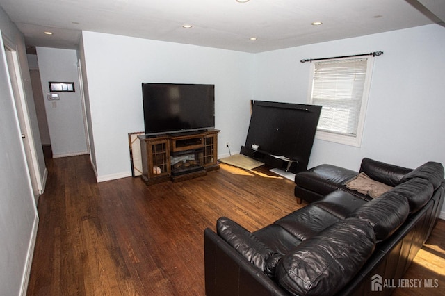 living area with baseboards, wood finished floors, and recessed lighting