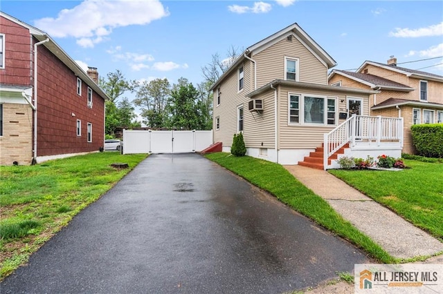 view of side of home with a gate and a wall mounted AC