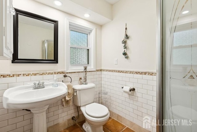 bathroom with tile patterned floors, a wainscoted wall, toilet, recessed lighting, and tile walls