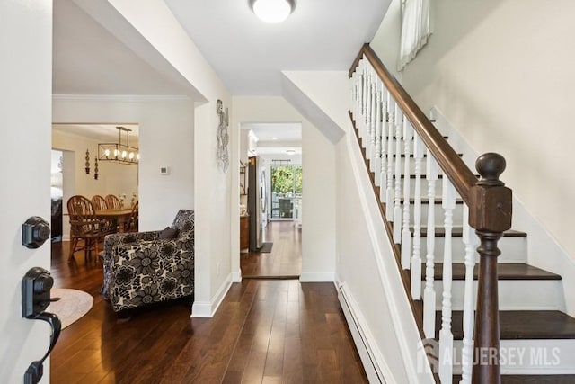 entrance foyer with stairway, baseboards, baseboard heating, and hardwood / wood-style floors