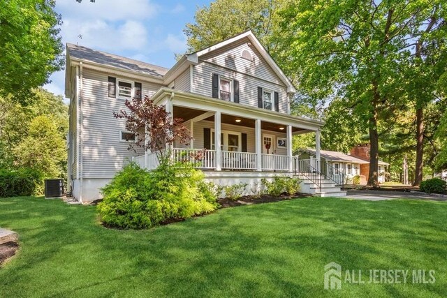 view of front of property with a porch, a front yard, and central AC unit