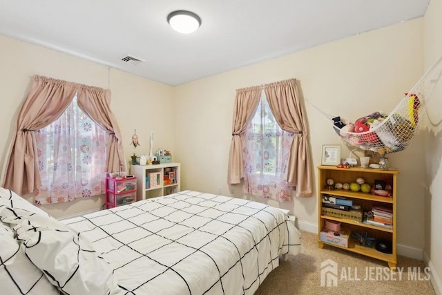 carpeted bedroom featuring baseboards and visible vents