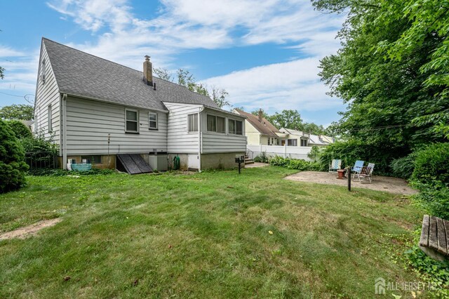 958 Apgar Ter, Rahway, NJ 07065 - back of house with a chimney, a patio area, and roof with shingles