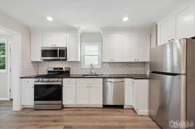 763 Prospect Ave, Old Bridge, NJ 08879 - kitchen featuring stainless steel appliances, dark countertops, white cabinetry, recessed lighting, and ornamental molding