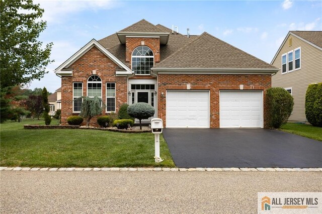 view of property with a garage and a front yard