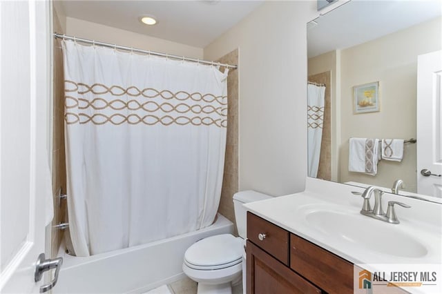 bathroom featuring toilet, shower / bath combo with shower curtain, and vanity