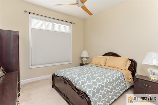 carpeted bedroom with ceiling fan and baseboards