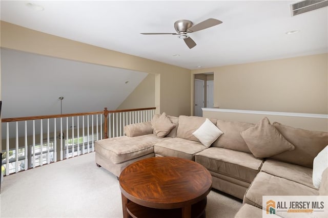 living room with visible vents, a ceiling fan, and light colored carpet